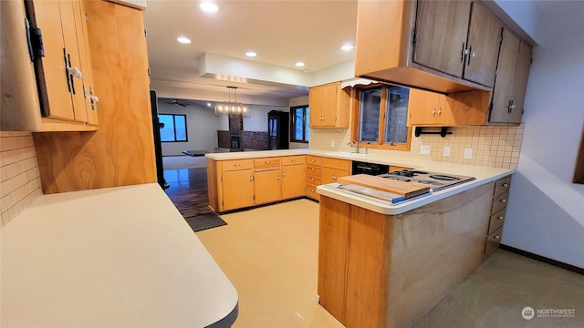 kitchen with a sink, tasteful backsplash, recessed lighting, a peninsula, and light countertops