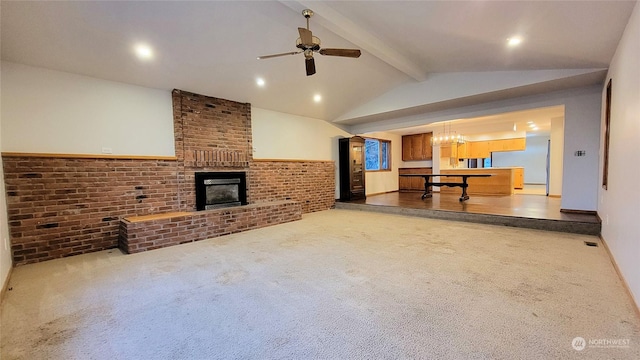 living room with carpet, a ceiling fan, brick wall, vaulted ceiling with beams, and a fireplace