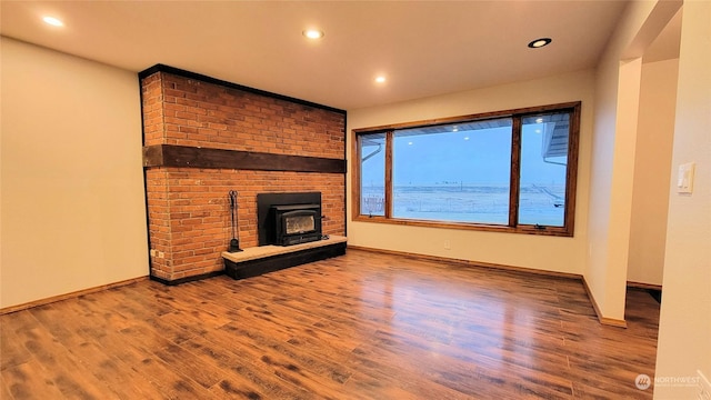 unfurnished living room with recessed lighting, baseboards, and wood finished floors