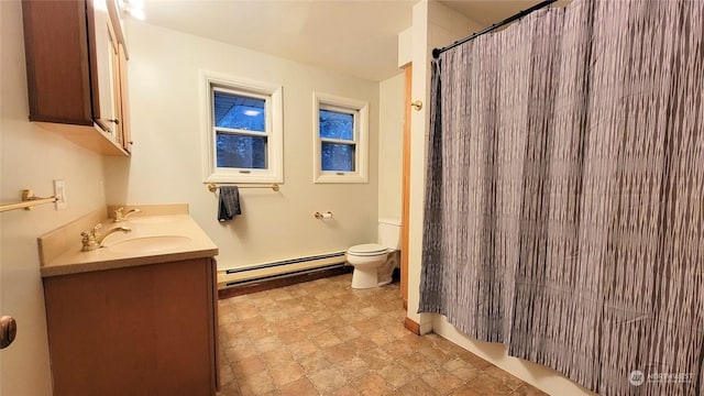 bathroom featuring double vanity, a baseboard radiator, toilet, and a sink