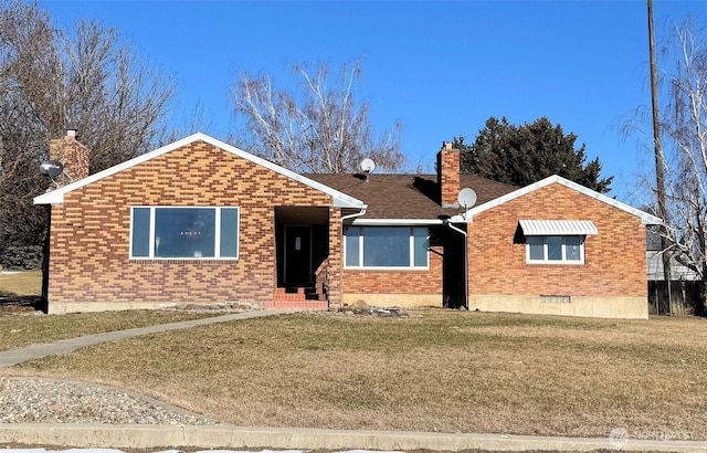 ranch-style home with a front yard, brick siding, and a chimney