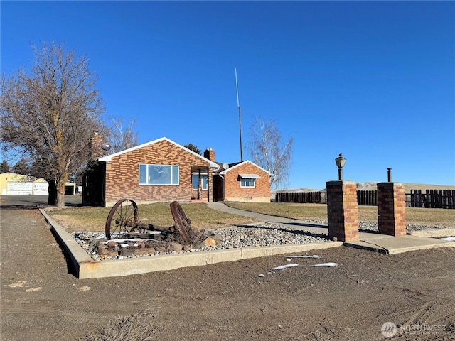 ranch-style house featuring a fenced front yard, brick siding, and a front yard