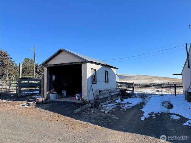 view of outbuilding featuring an outdoor structure, fence, and central AC