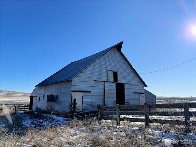 view of property exterior featuring an outbuilding, a barn, and fence