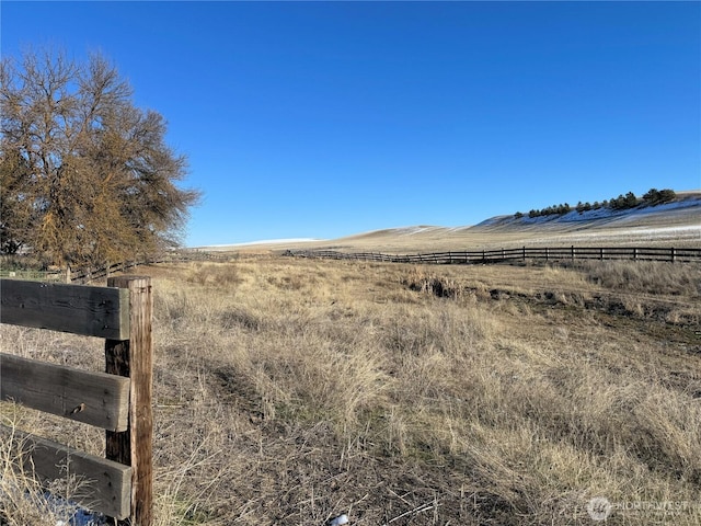 view of yard featuring a rural view and fence