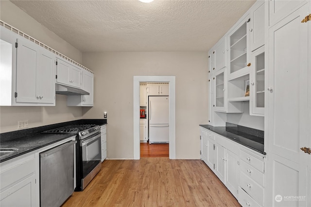 kitchen featuring white cabinets, light wood-type flooring, a textured ceiling, and appliances with stainless steel finishes