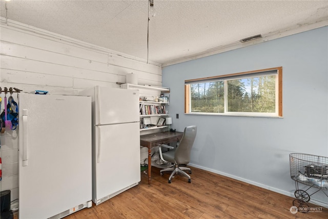 home office with a textured ceiling and hardwood / wood-style flooring