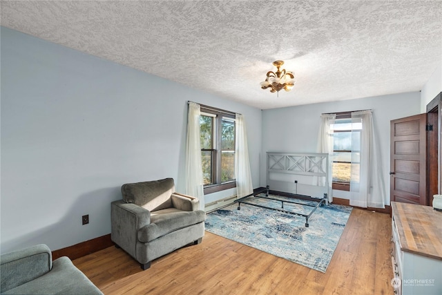 sitting room with a chandelier, a textured ceiling, and hardwood / wood-style flooring