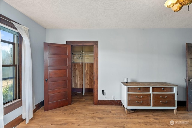 unfurnished bedroom featuring hardwood / wood-style flooring, a textured ceiling, and a closet