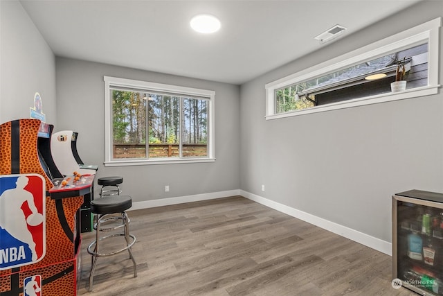 living area featuring hardwood / wood-style floors, a wealth of natural light, and beverage cooler