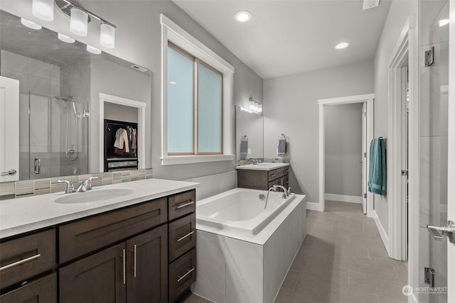 bathroom with tile patterned floors, vanity, and independent shower and bath