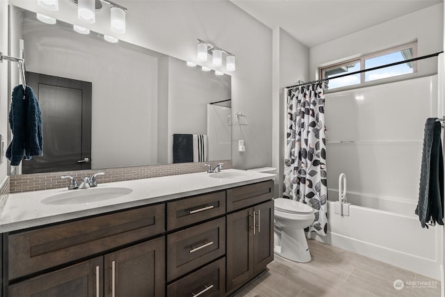 full bathroom featuring decorative backsplash, vanity, shower / tub combo with curtain, and toilet