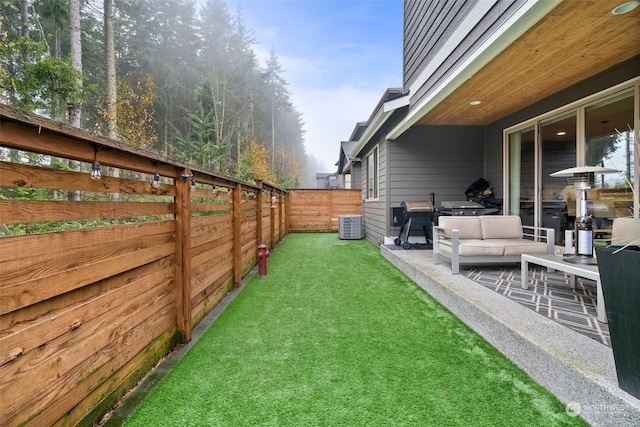 view of yard with central AC unit and a patio