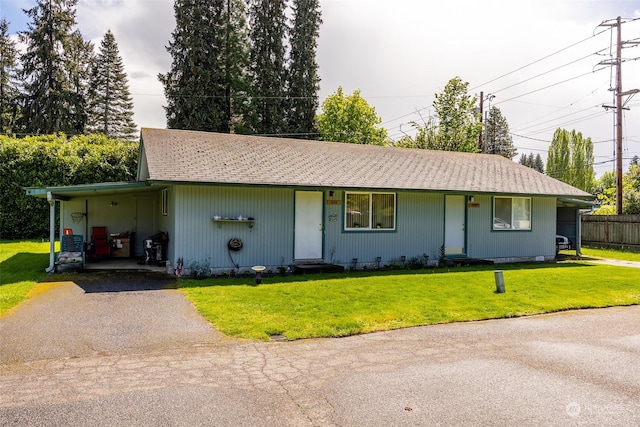 ranch-style home featuring a carport and a front lawn