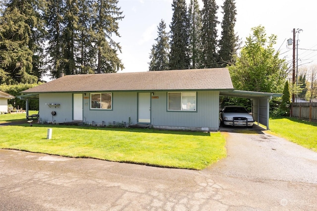 ranch-style home featuring a front lawn and a carport