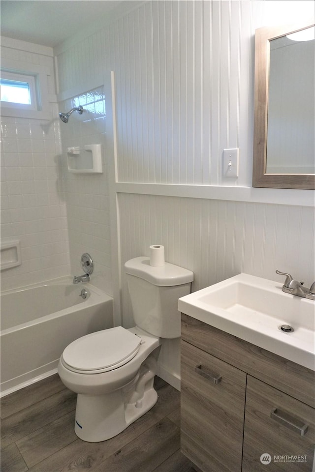 full bathroom with hardwood / wood-style floors, vanity, toilet, and tiled shower / bath