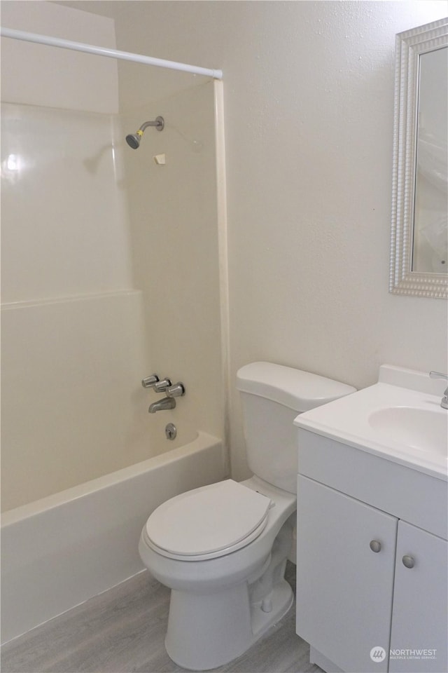 full bathroom featuring vanity, hardwood / wood-style flooring, toilet, and shower / washtub combination