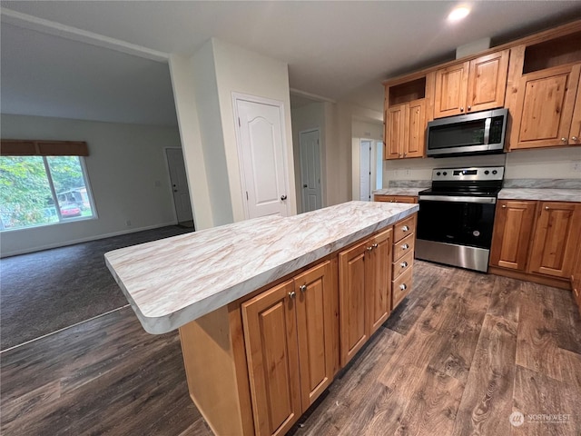 kitchen featuring dark hardwood / wood-style floors, a center island, stainless steel appliances, and a breakfast bar area