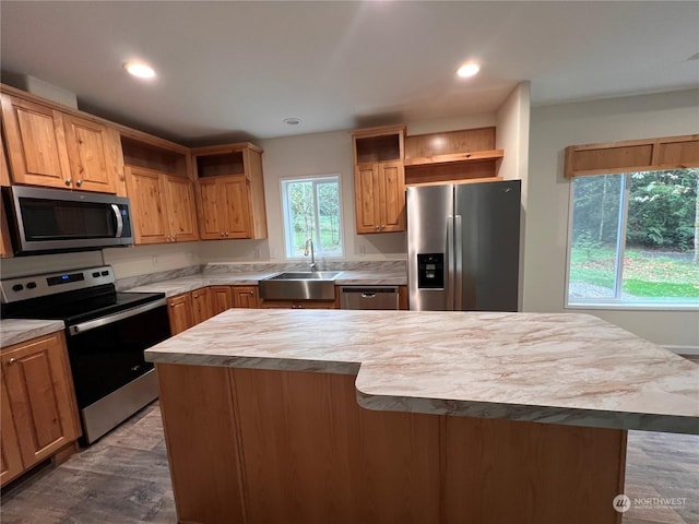 kitchen with wood counters, stainless steel appliances, a kitchen island, and sink