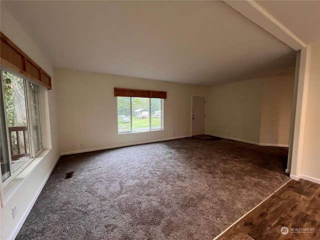 spare room featuring dark colored carpet