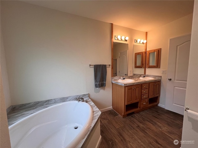 bathroom featuring hardwood / wood-style floors, a washtub, and vanity