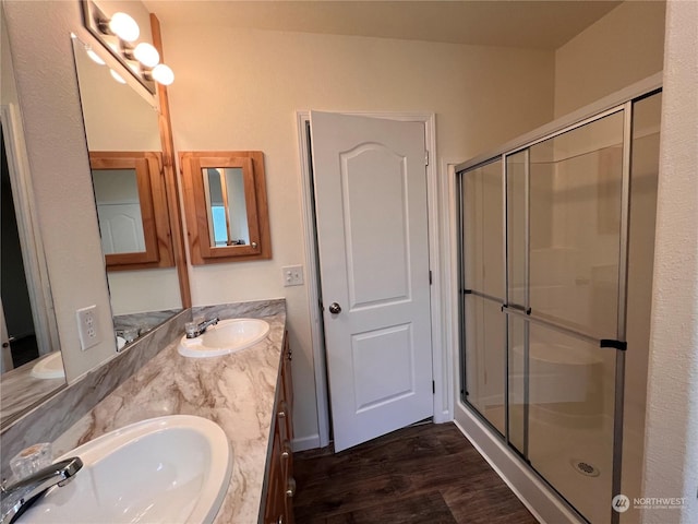 bathroom featuring vanity, hardwood / wood-style flooring, and a shower with door