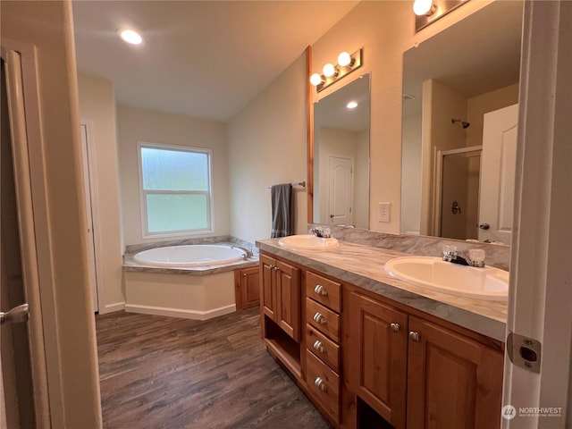 bathroom with hardwood / wood-style flooring, vanity, and plus walk in shower