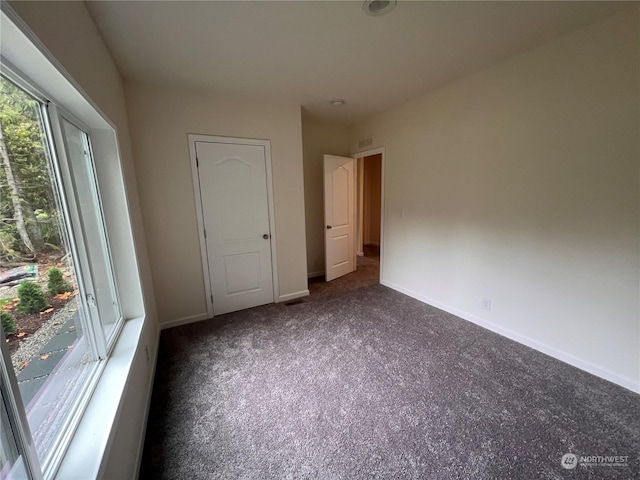 unfurnished bedroom featuring dark carpet