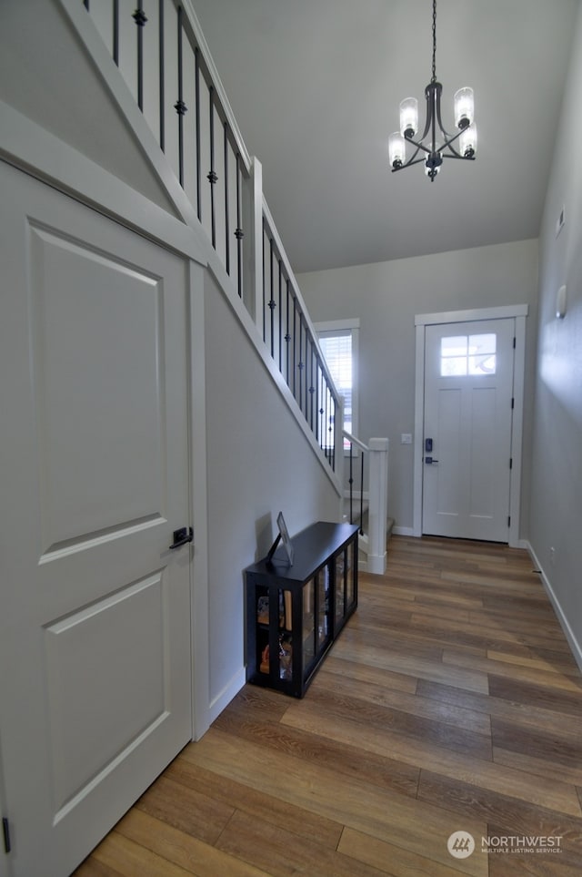 foyer with hardwood / wood-style floors and an inviting chandelier