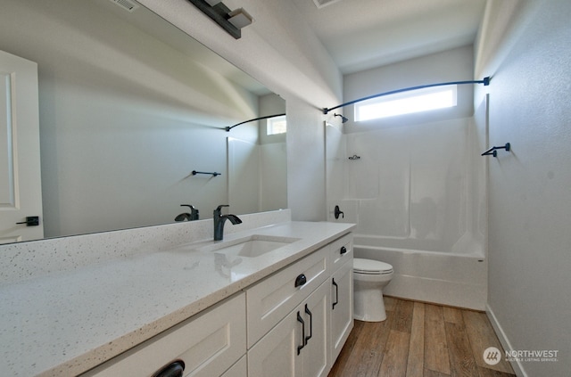 full bathroom featuring wood-type flooring, bathtub / shower combination, vanity, and toilet