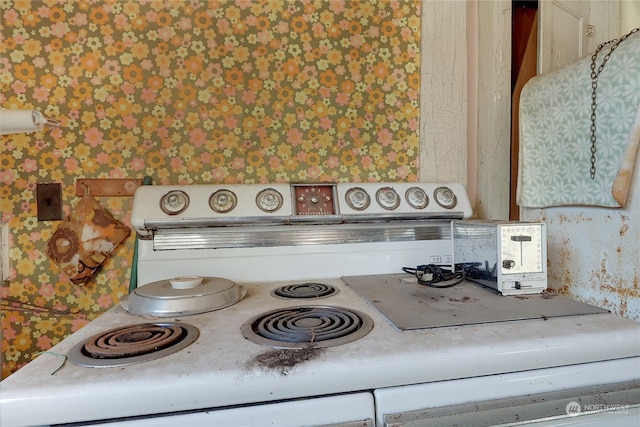 interior details featuring wallpapered walls and white electric range oven