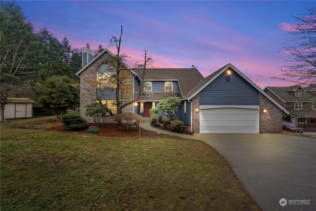 view of front of house featuring a yard, a garage, and a storage shed