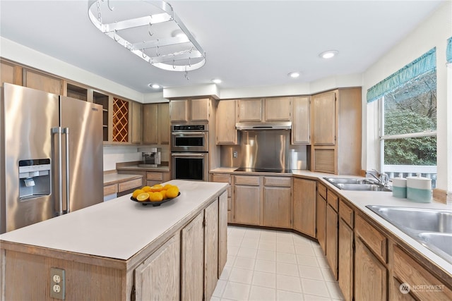 kitchen with appliances with stainless steel finishes, a center island, and sink