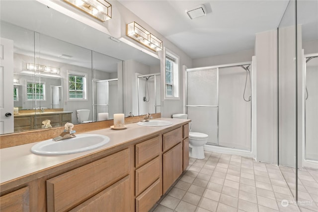 bathroom with tile patterned floors, plenty of natural light, and a shower with shower door