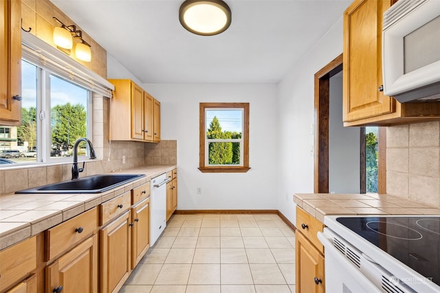 kitchen featuring sink, backsplash, tile countertops, white appliances, and light tile patterned floors