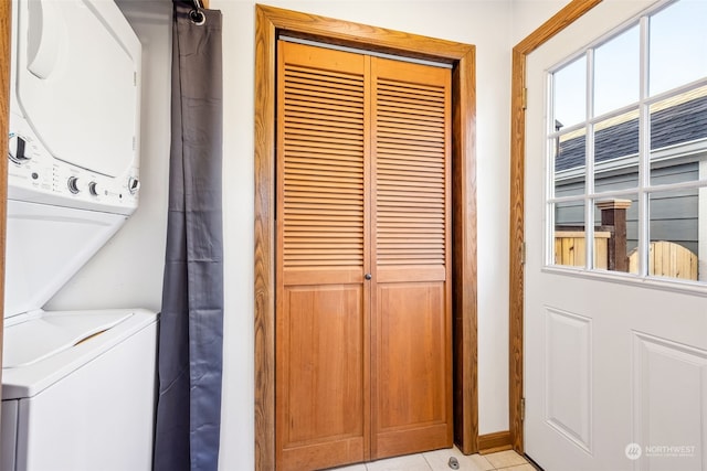 laundry room with stacked washer / drying machine and light tile patterned floors