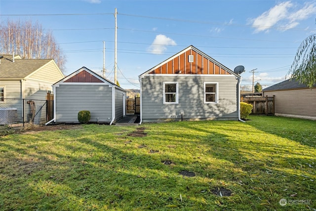 back of house with a yard and a shed