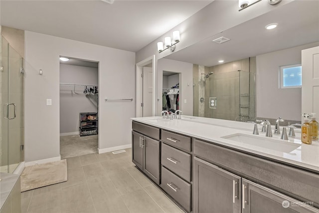 bathroom featuring tile patterned flooring, vanity, and a shower with shower door