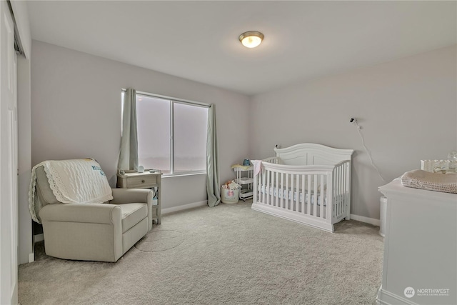 bedroom with light carpet and a nursery area