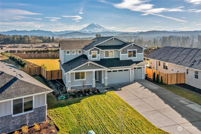 craftsman inspired home with a mountain view, a garage, and a front lawn