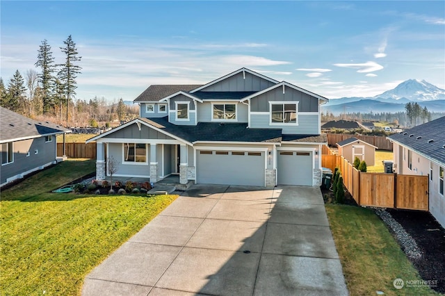 view of front of home with a mountain view, a porch, a front yard, and a garage