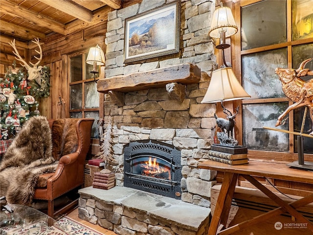 interior space with beamed ceiling, a stone fireplace, wood ceiling, and hardwood / wood-style floors