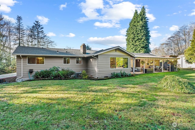 back of house featuring a lawn