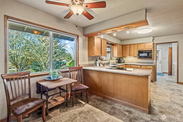 kitchen featuring kitchen peninsula, a textured ceiling, ceiling fan, stainless steel gas cooktop, and sink