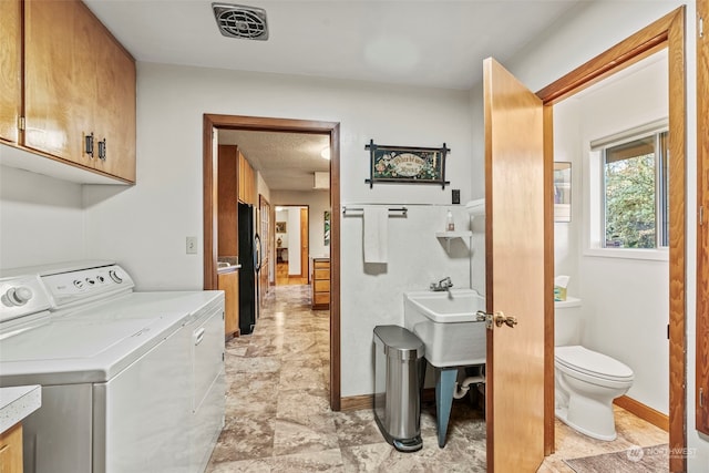 laundry room featuring separate washer and dryer and cabinets