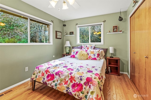 bedroom with ceiling fan, a closet, and light hardwood / wood-style floors