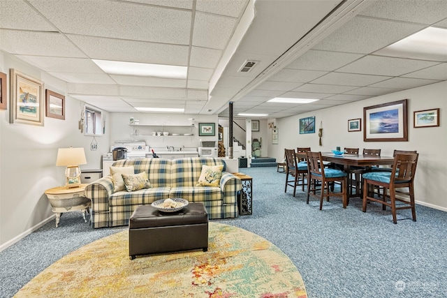 carpeted living room with a paneled ceiling