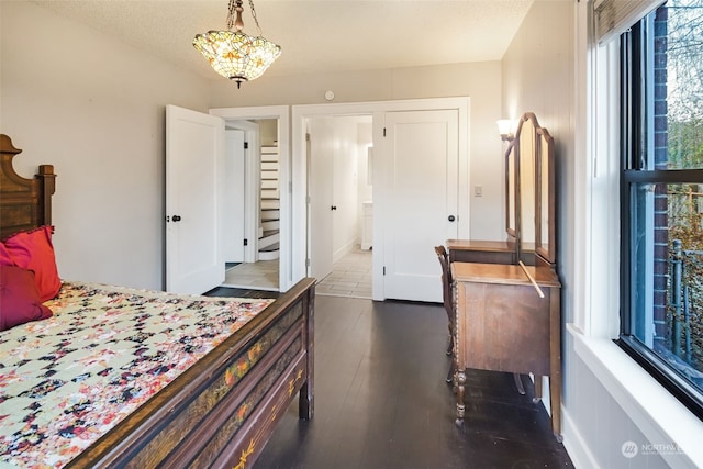 bedroom with a textured ceiling, a chandelier, and dark hardwood / wood-style floors