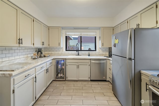 kitchen with stainless steel appliances, wine cooler, tasteful backsplash, and sink