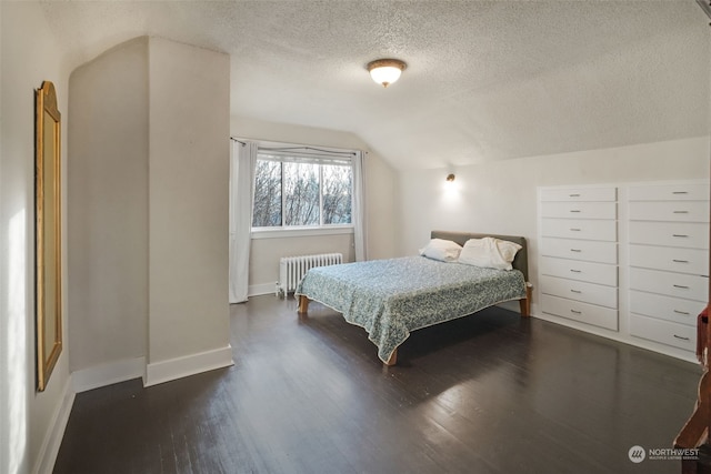 bedroom with radiator heating unit, a textured ceiling, vaulted ceiling, and dark wood-type flooring